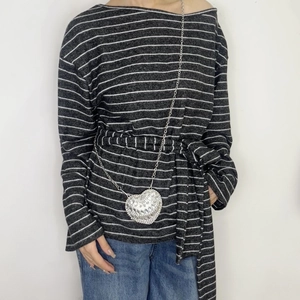 Detail of silver heart-shaped mini crossbody bag with rhinestone texture and chain strap