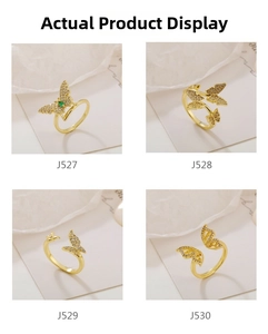 Detail view of gold butterfly rings J527-J530 featuring zircon pavé and green gemstone