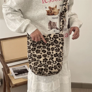Detailed view of leopard print plush shoulder bag on model with soft velvet texture