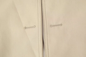 Close-up of premium khaki trench coat featuring twill texture and precision stitching