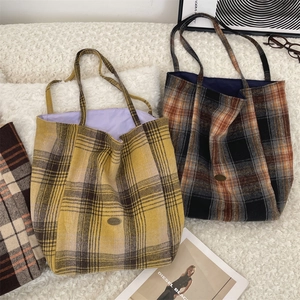 Three colors of wool checkered tote bags with metal logos on a soft white carpet background