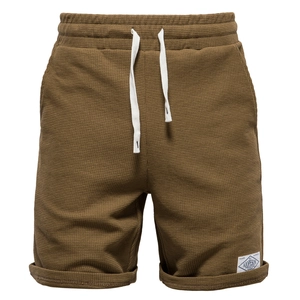 Detail of brown waffle knit sports shorts featuring elastic waist and white drawstring