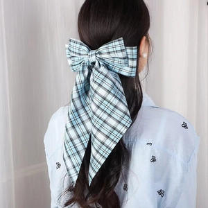 Plaid blue oversized hair bow with streamers on model back view in college style
