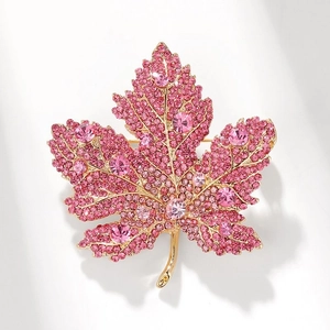 Sparkling maple leaf brooch with pink rhinestones and crystals on a gold-plated base