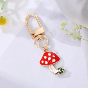 Detail of red mushroom pendant keychain with gold alloy clasp and colorful enamel finish