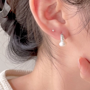 Elegant 925 sterling silver pearl earrings shown on model for a minimalist style