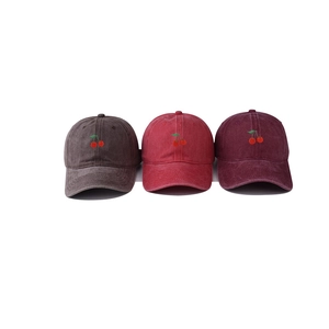Detailed embroidery of red cherries on washed cotton baseball caps in various colors