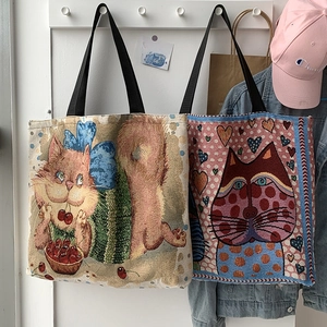 Detail of artistic cat print canvas tote bags hanging on a wall with thick woven texture