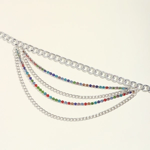 Détail d'une chaîne de taille multicouche avec maillons argentés et strass arc-en-ciel
