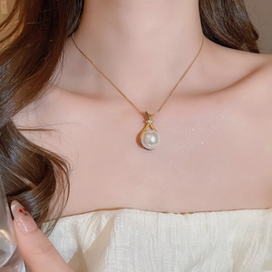 Detailaufnahme einer Goldkette mit einem geometrischen Zirkon-Perlenanhänger an einem Modell