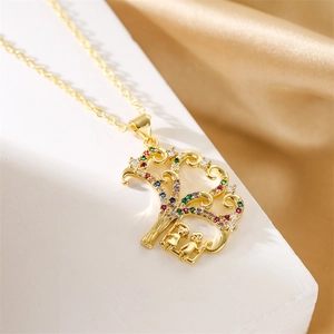 Détail du collier arbre de vie doré avec cristaux colorés sur fond de soie champagne