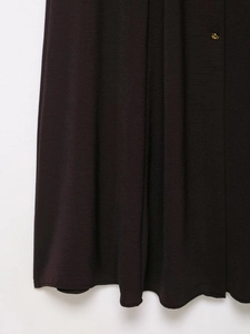 Close-up of brown knit dress fabric featuring elegant golden button and smooth texture
