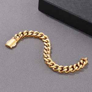 Detailed view of an 18K gold-plated Cuban link chain bracelet on a textured grey background