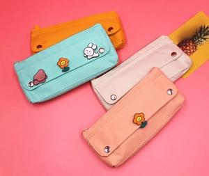Detail of four colorful oxford cloth pencil cases with cute cartoon flap designs