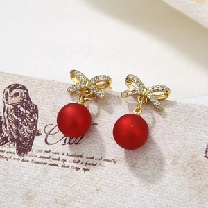 Elegant bow-knot earrings with red matte pearls and gold zircon inlay on vintage card