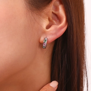 Gros plan de boucles d'oreilles en zircon coloré portées par un mannequin en or 18 carats