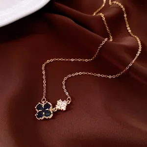 Collier à fleurs plaqué or 18k avec trèfles bleu marine sur fond de soie rouge luxueux