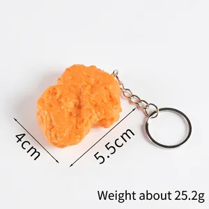 Realistic PVC fried chicken nugget keychain with silver metal ring on white background