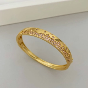 Vue macro d'un bracelet doré avec un pavage de zircons roses et violets étincelants