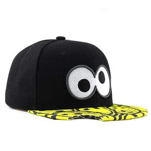 Detail of cartoon eye embroidery on a black and yellow flat brim hip hop cap