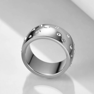 Macro shot of 10mm wide polished stainless steel ring with scattered crystal accents