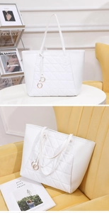 Detail of white quilted tote bag with golden rings and geometric triangular stitching