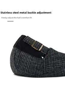 Detail of adjustable bronze metal buckle and plaid fabric texture on a flat cap
