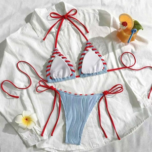 Détail du bikini bleu texturé avec bordures en corde tressée rouge et liens à nouer