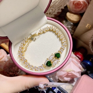 Close-up of vintage gold bracelet with green spinel gemstones in a pink gift box