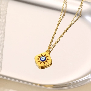 Golden stainless steel necklace featuring a square evil eye pendant on a silver tray