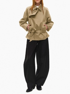 Detail of khaki short trench coat featuring asymmetrical double-breasted closure and waist belt