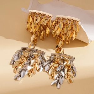Elegant gold and silver leaf tassel earrings displayed on white ceramic art props