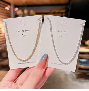 Detail view of gold and silver twisted titanium steel necklaces on display cards