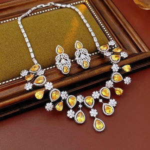 Detail of luxury yellow pear-cut zircon necklace and earring set on green velvet