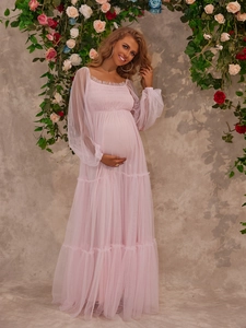 Detailed view of pink maternity tulle gown with sheer puff sleeves in a floral setting