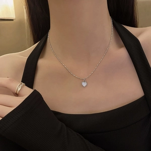 Close-up of a heart-shaped pearl pendant on a delicate titanium steel necklace chain