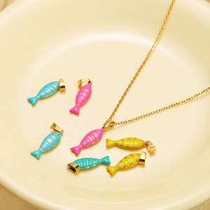 Detail of colorful enamel fish charms in pink, blue, and yellow with golden metal plating