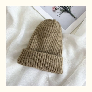Detailed macro view of the soft ribbed knit texture on the camel brown beanie hat