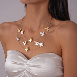 Detailed view of layered metallic necklace with matte gold and silver butterfly charms