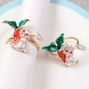 Detail of silver bunny napkin rings with red carrots and sparkling ruby gem eyes