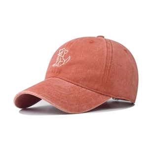 Detail of vintage washed cotton baseball cap with white dog embroidery in terracotta