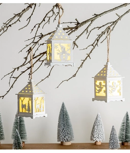 White LED Christmas lanterns with cutout snowman reindeer and angel designs on branch