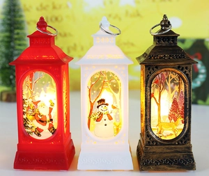 Three Christmas LED lanterns with Santa and snowman patterns in a warm festive setting