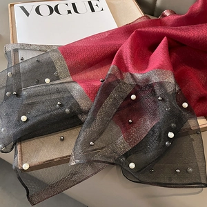 Detail of silk-like shawl with wine red panels, black sheer mesh, and pearl embellishments