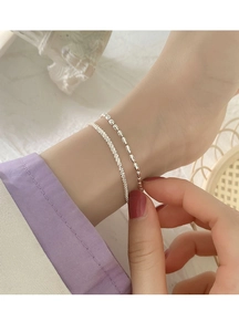Nahaufnahme des zweilagigen S925-Silberarmbands mit polierten Perlen am Handgelenk