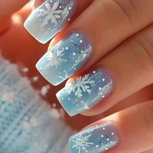 Unghie finte blu sfumate con fiocchi di neve a rilievo e glitter argento scintillanti