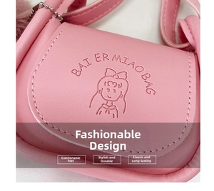 Close-up of pink mini crossbody bag with cartoon girl pattern and plush ball detail