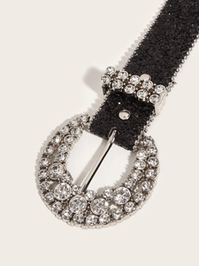 Close-up of sparkling rhinestone horseshoe buckle and glittering black belt strap