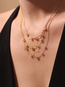 Gros plan d'un collier multicouche doré 18 carats avec lettres MAMA et pendentif cœur