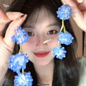 Detailed view of handmade blue acrylic flower drop earrings with golden rod link